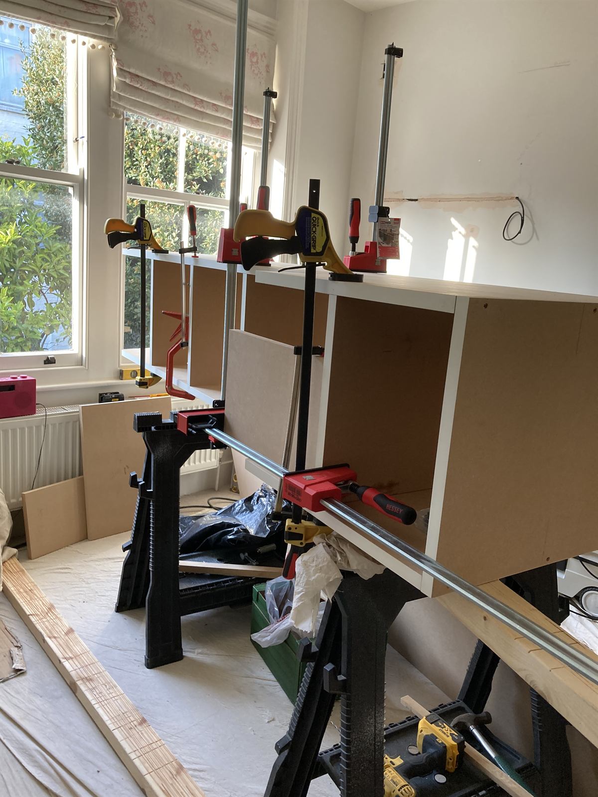 Built-in cabinet carcasses held in clamps during assembly