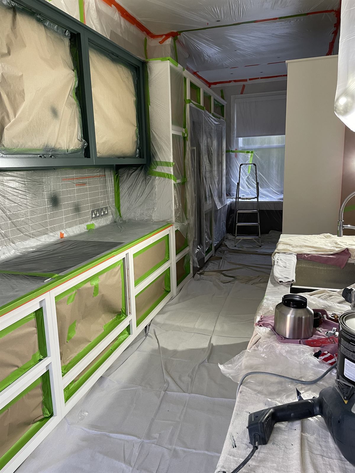 Kitchen fully masked and sheeted, ready for cabinet spraying